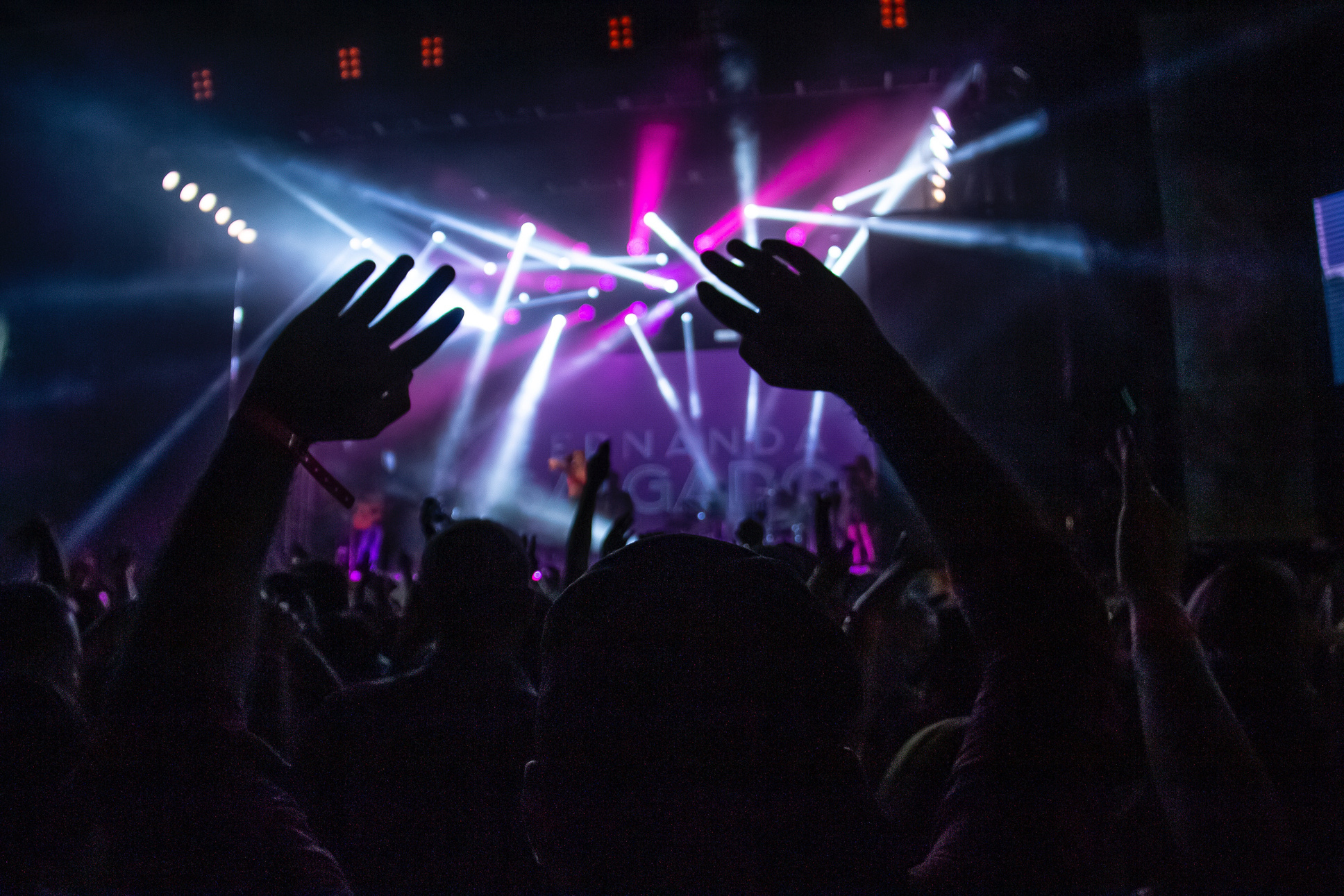 people at a concert with their hands up in the air