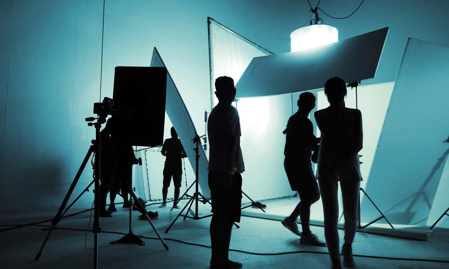 silhouettes of people standing in front of a white backdrop